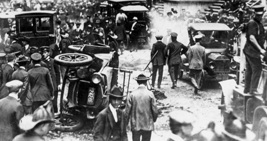 Crowds and overturned vehicles in the street outside the New York Stock Exchange after the 1920 Wall Street bombing